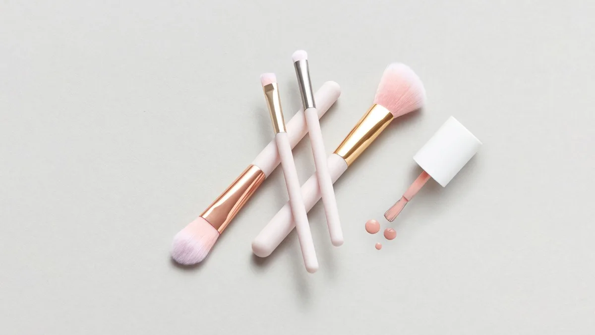 A flat lay of makeup brushes and spilled nail polish on a light surface for beauty concepts.