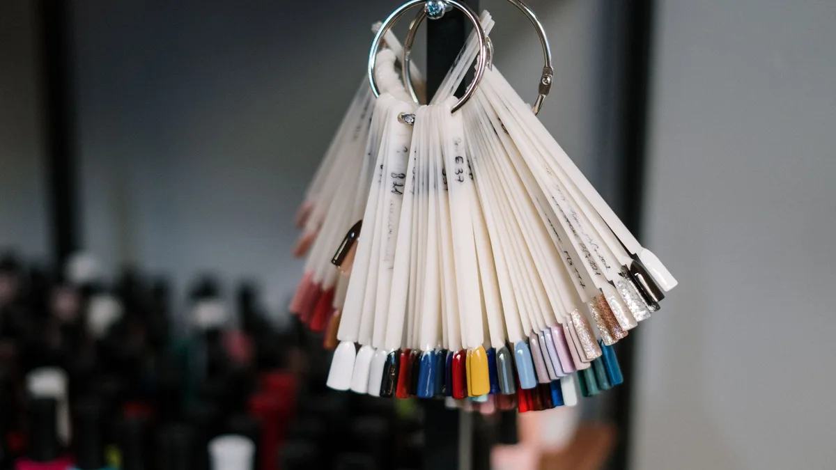 A vibrant display of nail polish swatches hanging in a beauty salon, showcasing diverse color options for manicure trends.