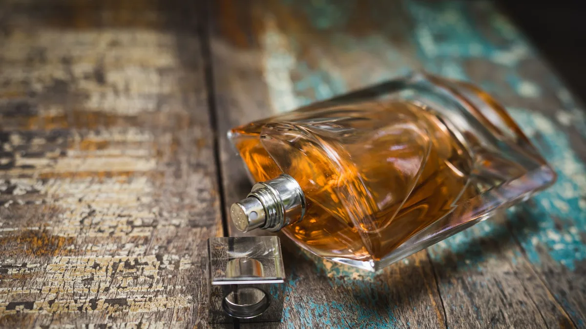 Artistic perfume bottle on rustic wooden surface, perfect for fragrance ads.